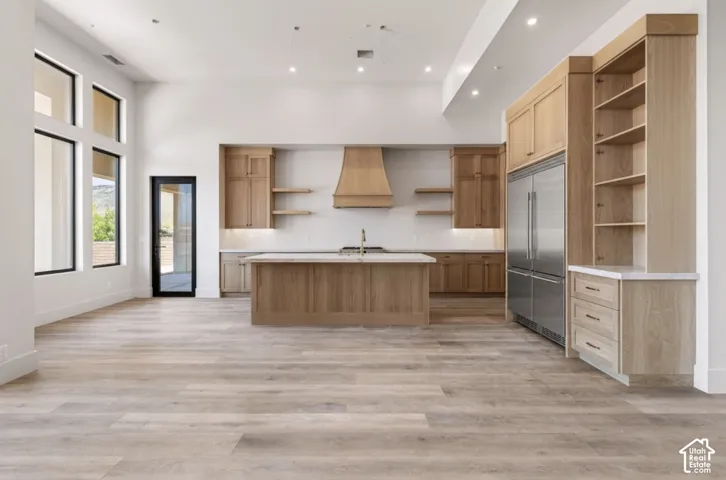Spacious open-concept room featuring high ceilings, wood-finish flooring, and expansive windows