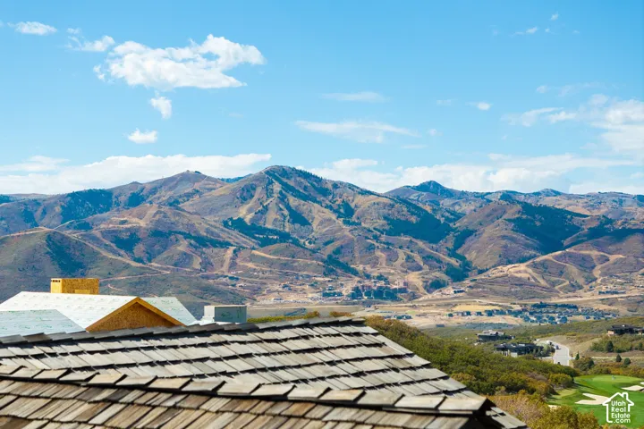 Mountain landscape featuring distant structures and a golf course