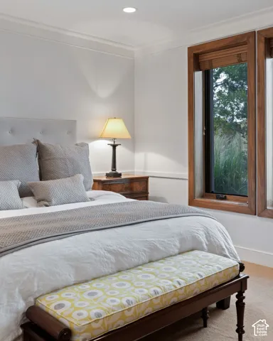 Recessed lighting, crown molding, wood-framed windows, built-in headboard, and wood-finish flooring