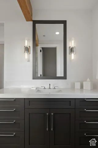Vanity with dark wood cabinetry, light-toned countertop, and undermount sink