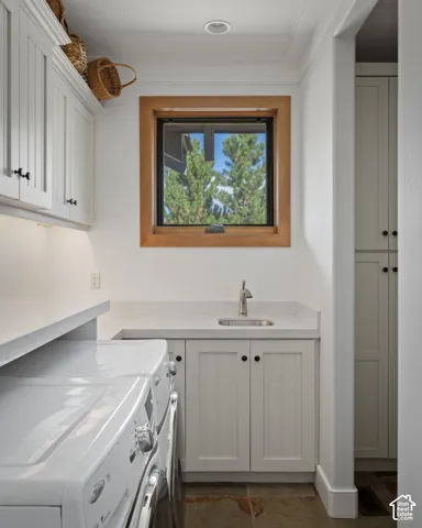 White cabinetry, solid surface countertops, a stainless steel sink with a gooseneck faucet, a wood-framed window, and recessed lighting
