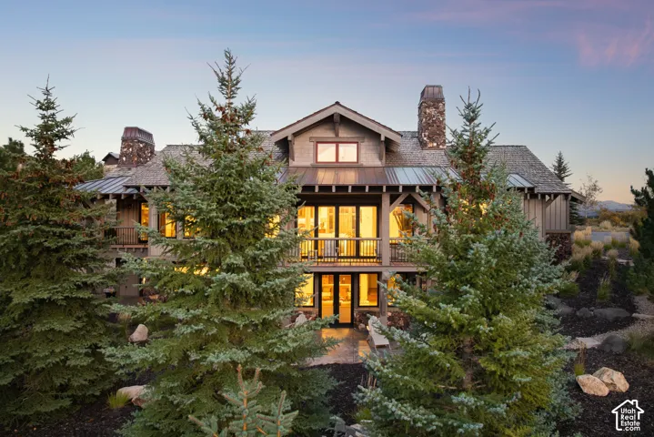 Stone and wood-sided exterior with multiple balconies and a covered entrance