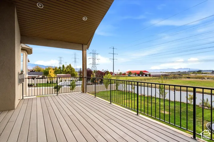 Covered balcony featuring composite decking and black metal railings