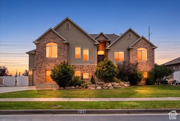 Stucco and stone facade with an arched entry and integrated garage