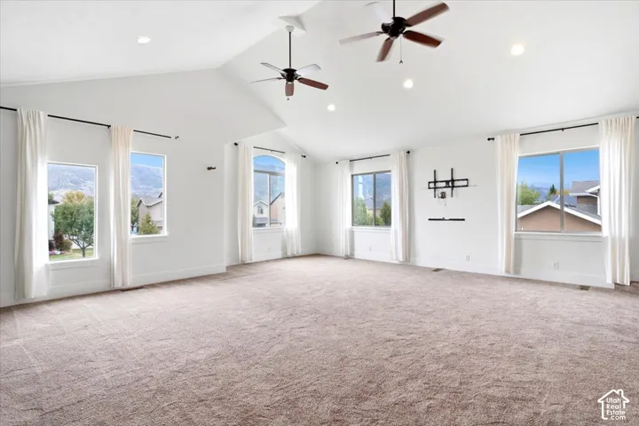 Vaulted ceiling with recessed lighting and two ceiling fans