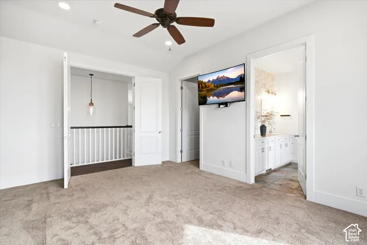 Plush carpet flooring and a ceiling fan with integrated lighting