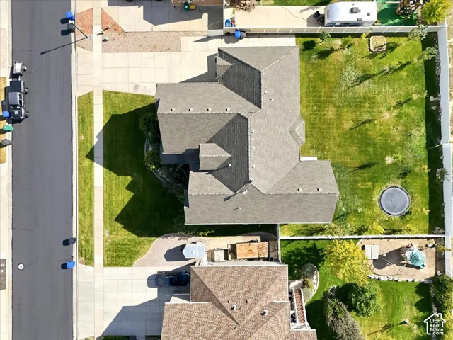 Expansive lot featuring a large residential structure with a shingled roof, a paved driveway, and a spacious green lawn