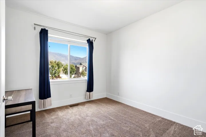 Carpeted room with a large window and white trim