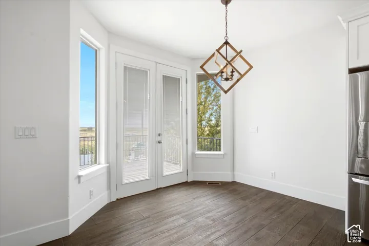 Wood-finish flooring, white walls, and a geometric chandelier with a bronze finish