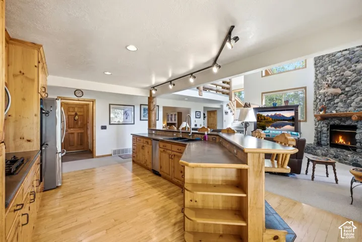 Kitchen featuring wood cabinetry, stainless steel appliances, and wood-finish flooring