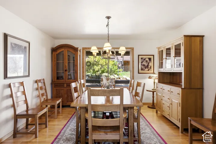 Hardwood flooring, natural wood window trim, chandelier lighting, and a built-in display cabinet
