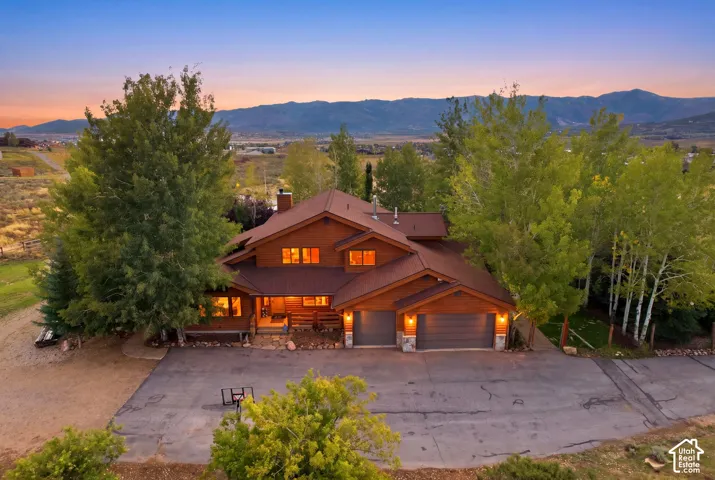 Cedar-sided exterior with a multi-level roofline, prominent two-car garage, and mature surrounding trees