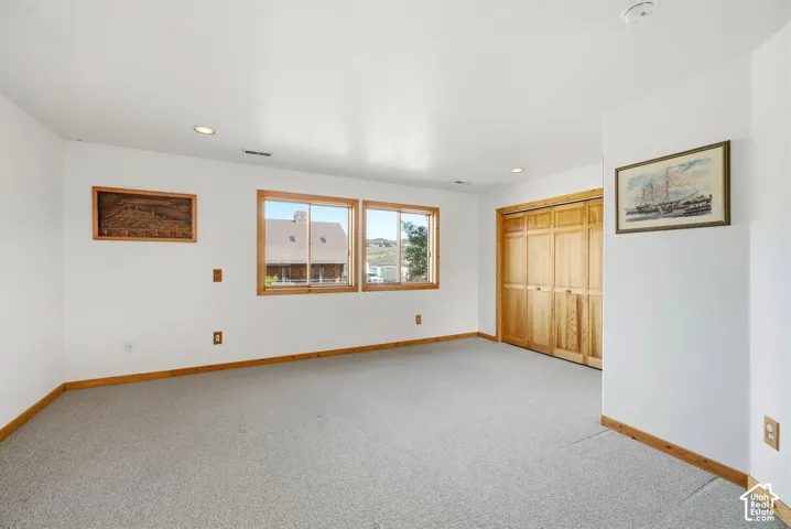Recessed lighting, wood-trimmed windows, wood bi-fold closet doors, and light-colored carpeting