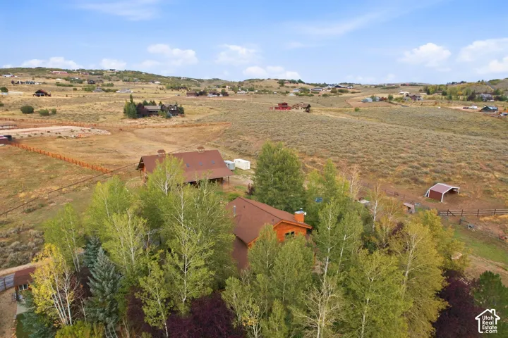 Property featuring extensive acreage, multiple structures, natural foliage, and a fence line