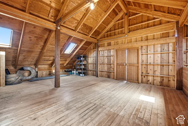 Hay Loft - Exposed wood beam construction, skylights, wood flooring, and built-in shelving