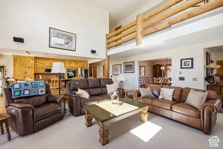 Vaulted ceiling, wood plank railing, wood-finish cabinetry, stainless steel appliances, and recessed lighting