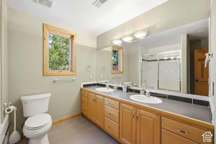 Dual vanity with oval undermount sinks and wood-finish cabinetry