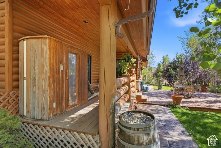 Wood-sided exterior with a covered porch featuring a sauna unit and wood plank decking