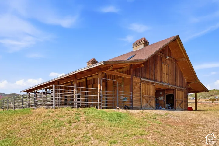 Wooden barn structure featuring a gabled roof, cupola, and sliding barn doors