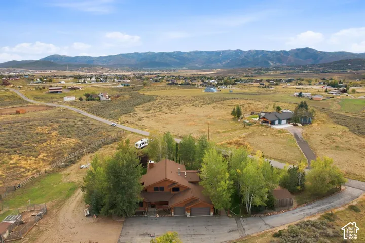 Mountain backdrop, expansive natural landscape, paved driveways, mature trees, multi-level structures