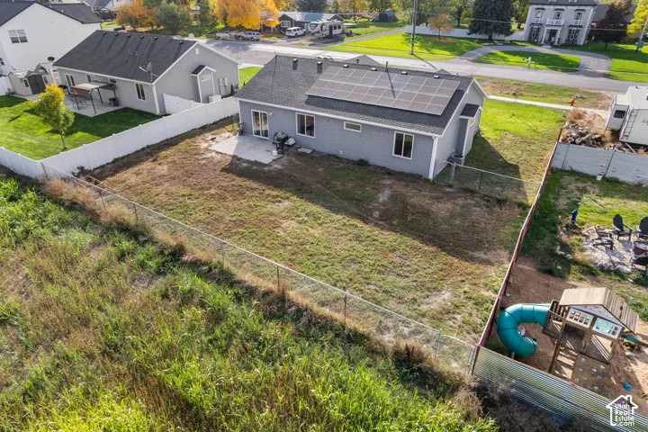 Single-story residence featuring a gray exterior, black roof, and rooftop solar panels