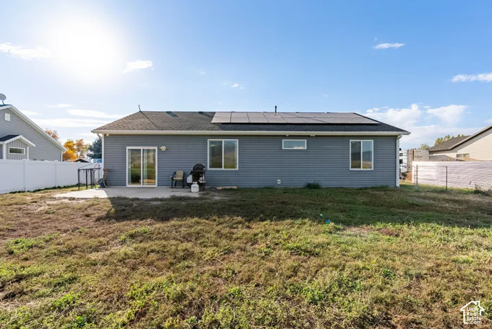 Rear exterior featuring a concrete patio, sliding glass door, and multiple windows