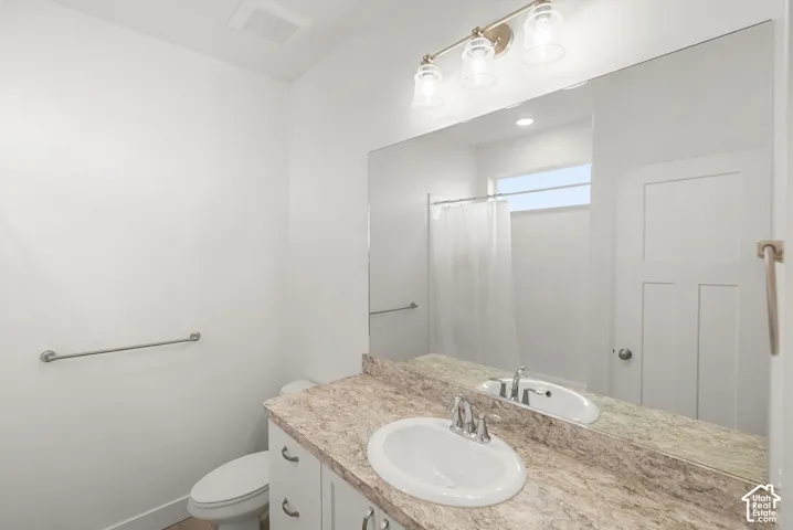 White vanity with a neutral-toned countertop and an undermount sink