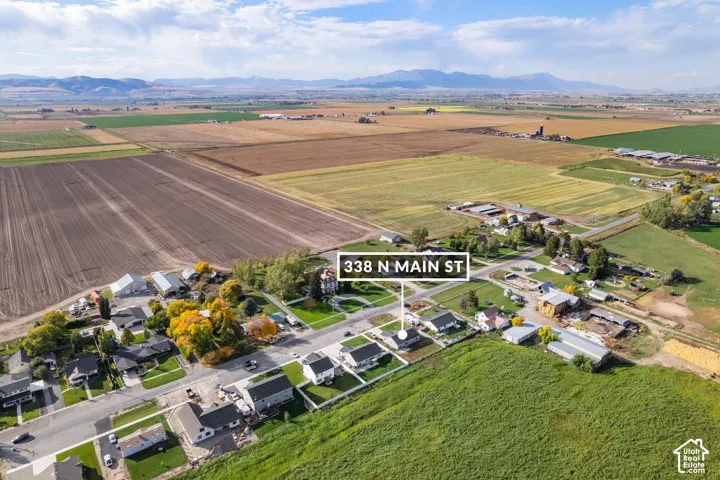 Aerial perspective of a residential area surrounded by agricultural fields and distant mountains