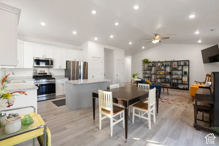 Modern kitchen with stainless steel appliances, white cabinetry, and light-toned countertops
