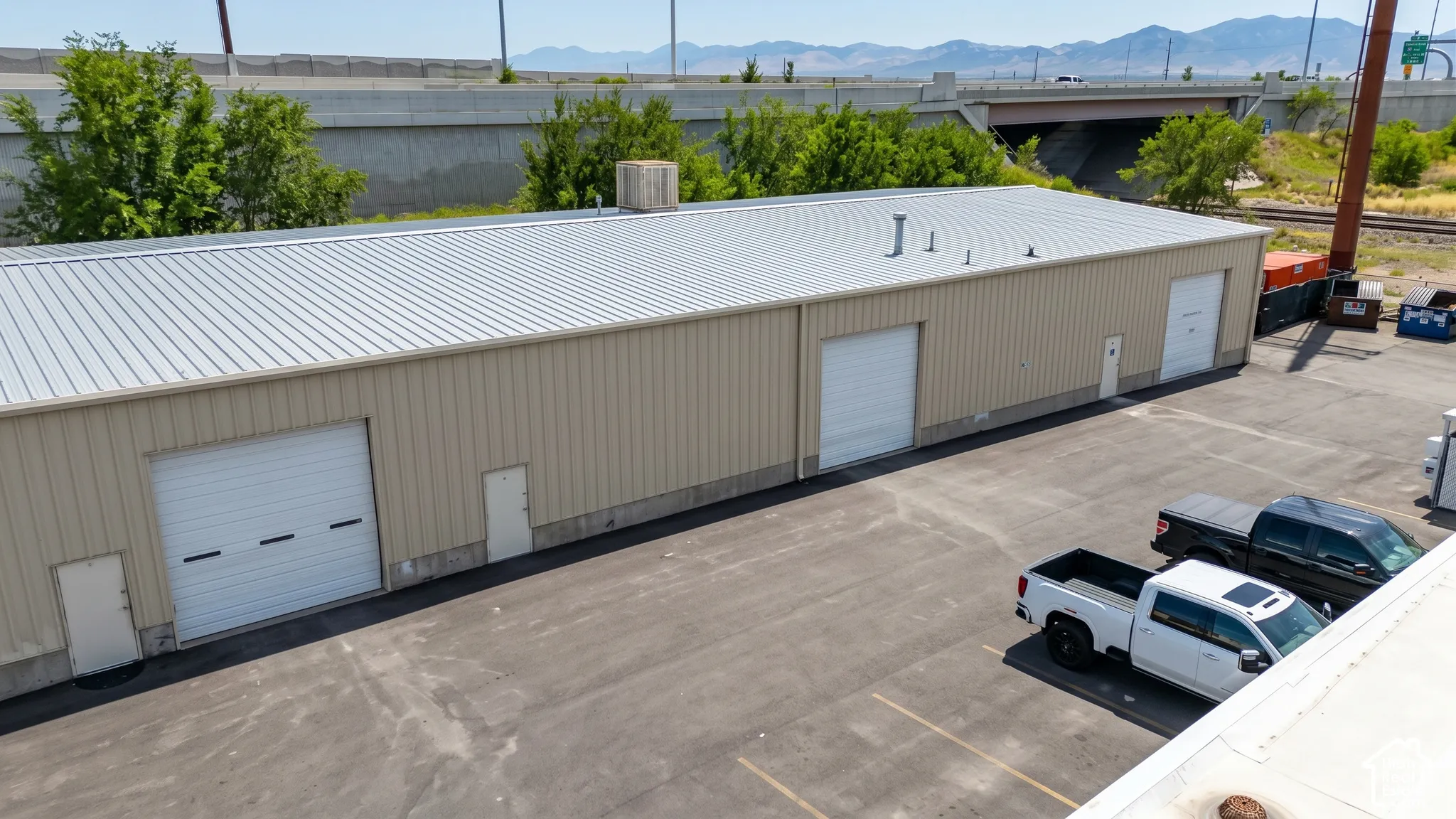 Industrial building with a metal roof and tan siding