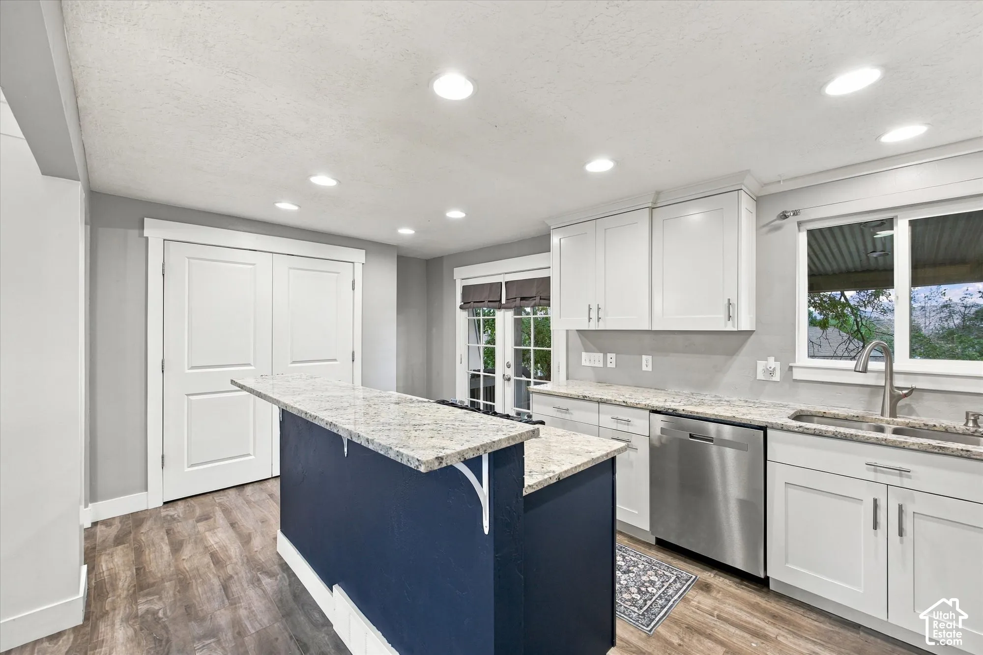 Kitchen featuring LVP flooring, recessed lighting, white shaker-style cabinetry, and Granite countertops