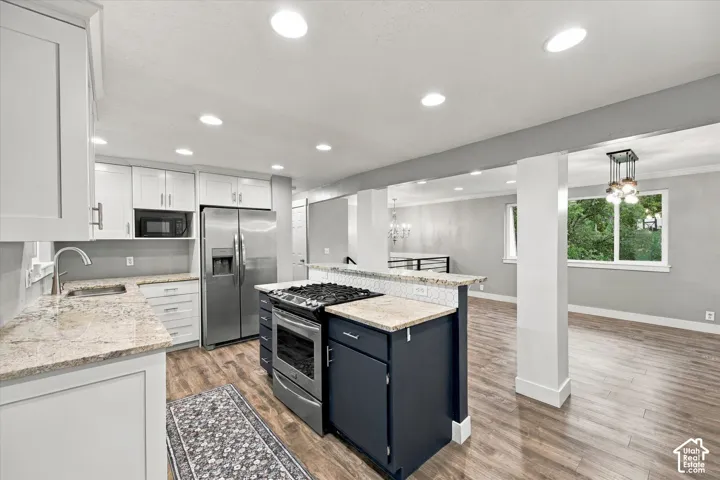 Kitchen featuring white cabinetry, stainless steel appliances, Granite countertops.
