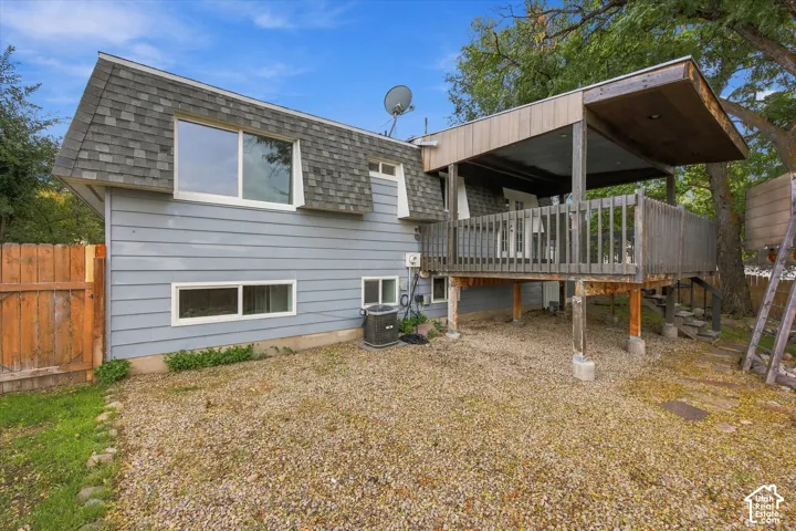 Exterior with light blue siding, a covered deck, and a wood privacy fence