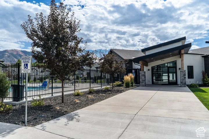 Modern architectural design with a prominent entrance featuring large glass panels and stone pillar accents