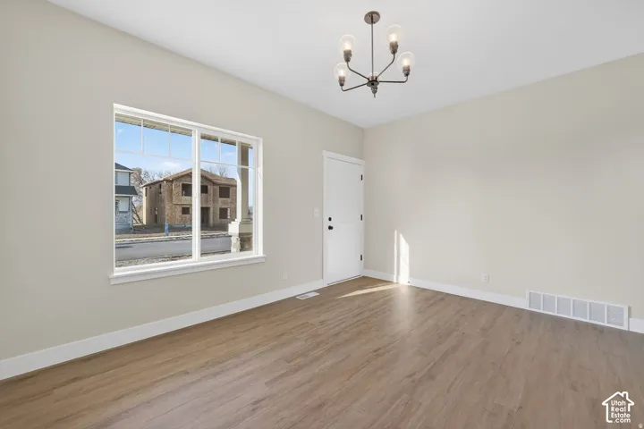 Wood-finish flooring throughout, bright white trim, and a contemporary four-light chandelier