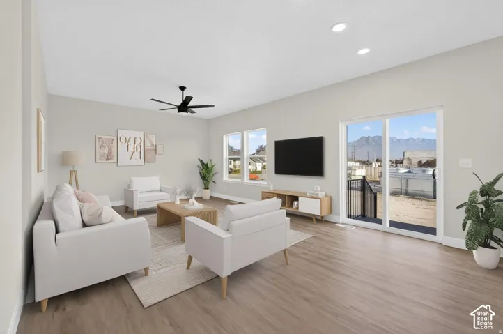 Spacious living area featuring wood-finish flooring, recessed lighting, and a modern ceiling fan