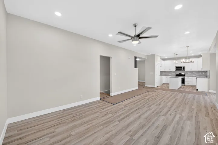 Wood-finish flooring throughout, complemented by recessed lighting and a ceiling fan