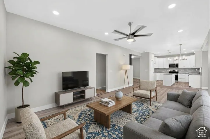 Open concept living area with wood-finish flooring, recessed lighting, and a modern ceiling fan
