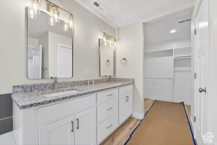 Dual vanity with granite countertops, undermount sinks, and contemporary light fixtures