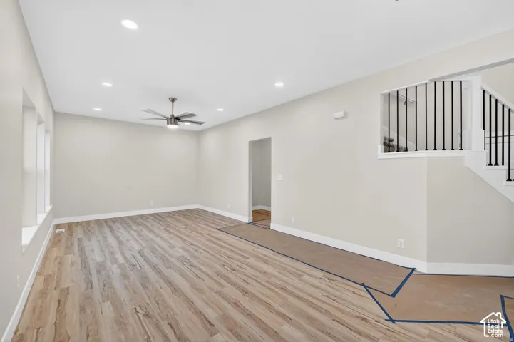 Spacious interior featuring wood-finish flooring, recessed lighting, and a contemporary ceiling fan