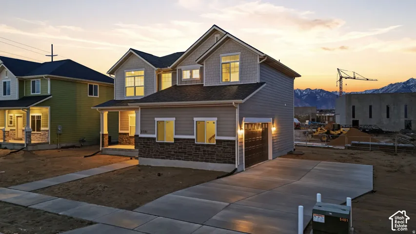 Two-story residence with a gray siding exterior and stone accents