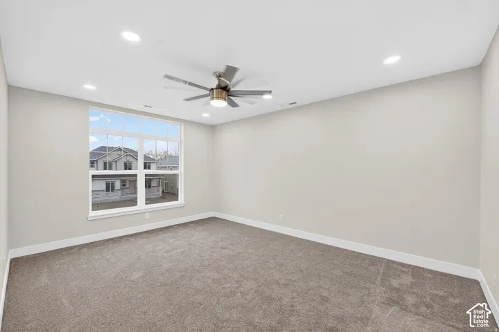 Recessed lighting, ceiling fan, expansive window, neutral wall color, and carpeted flooring