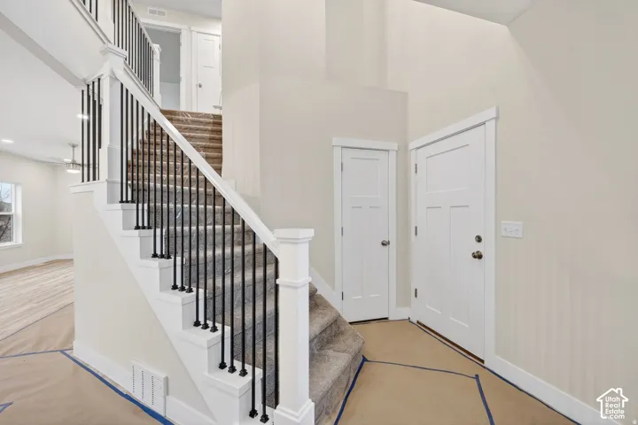 Staircase featuring black metal balusters and white risers
