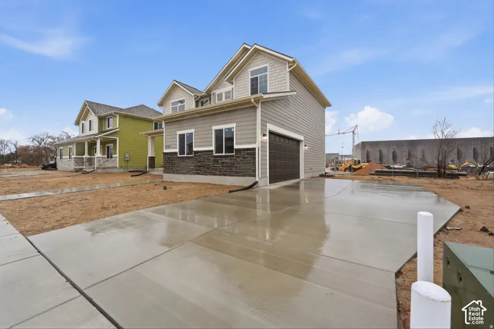Siding exterior with stone facade accents and a two-car garage