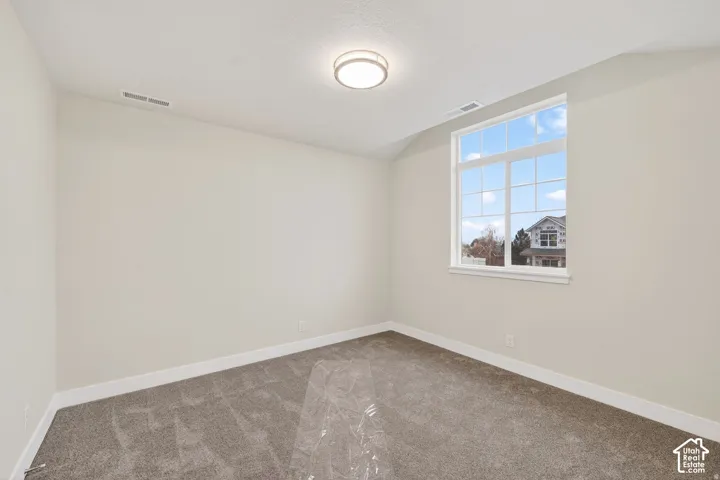 Neutral wall finishes, contemporary flush mount lighting, multi-pane window, white window trim, and gray carpet flooring