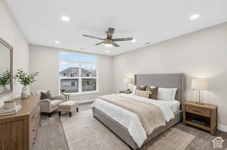 Recessed lighting, ceiling fan, large window, carpet flooring, and light wall tones