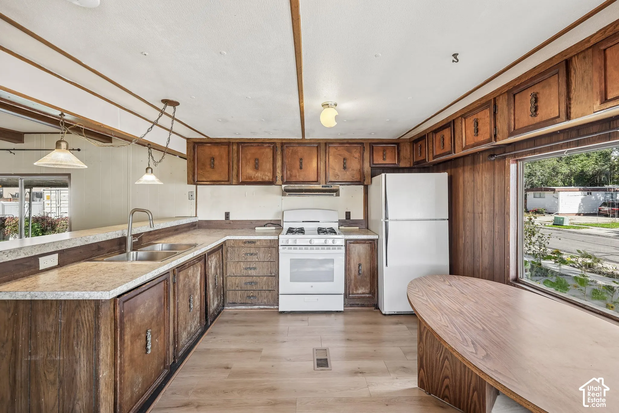 Kitchen featuring wood-finish cabinetry, light-toned countertops, and hard-surface flooring