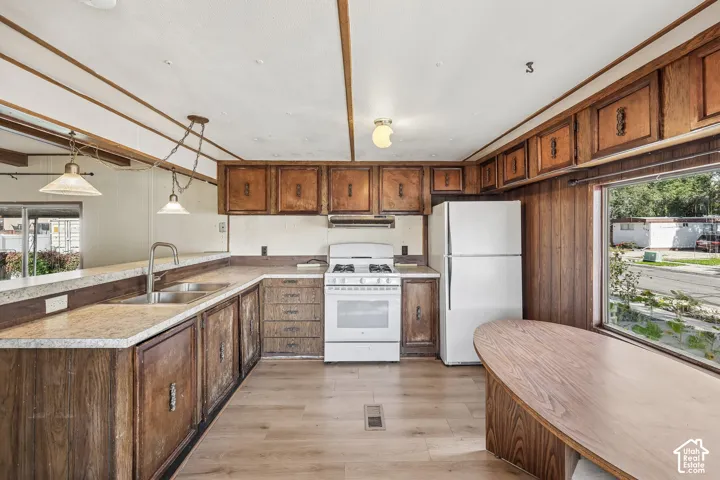 Kitchen featuring wood-finish cabinetry, light-toned countertops, and hard-surface flooring