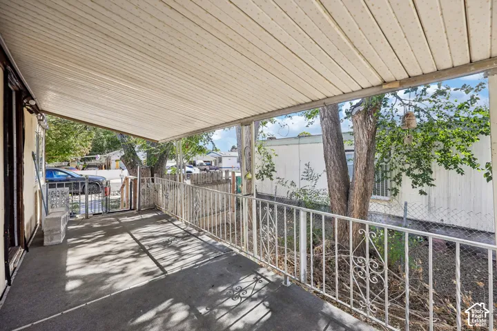 Covered porch with concrete flooring and decorative metal railing