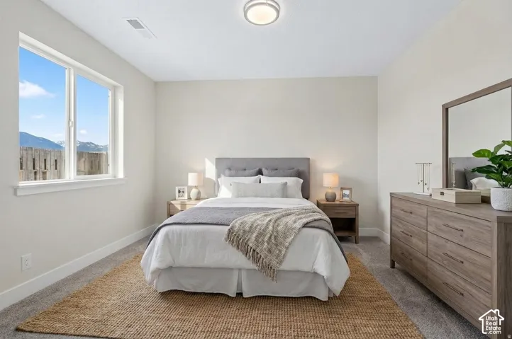 Recessed lighting with a flush-mount fixture, large window with mountain scenery, and light gray wall-to-wall carpeting